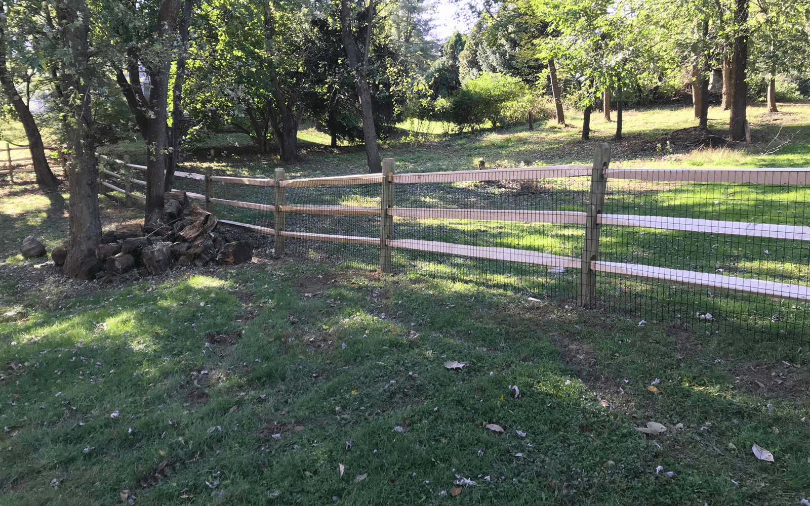 A wooden fence on a large yard