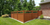A new wooden fence and a brick house